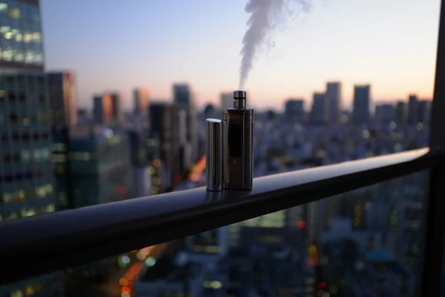都市の夜景と電子タバコ